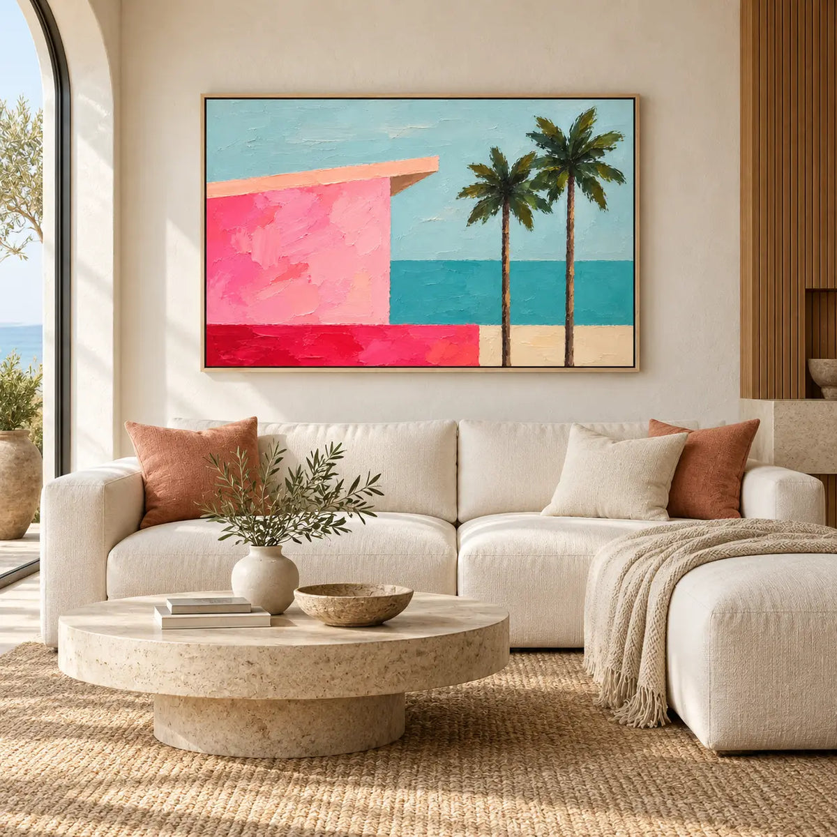 Coral Shore Pavilion above a curved ivory sofa with pink cushions and a stone coffee table