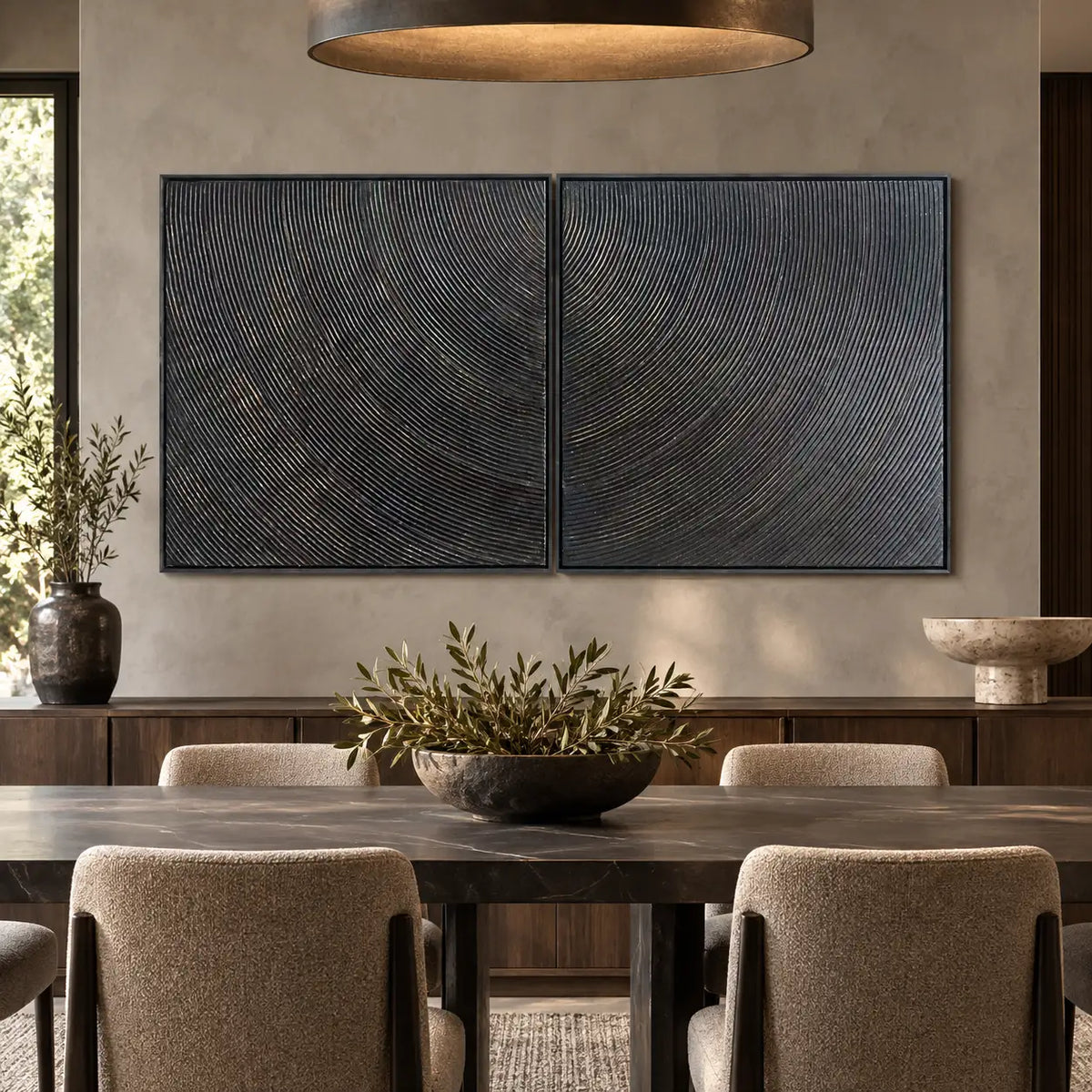 Two Rhythms in Charcoal: paired behind a dark stone dining table beneath a broad drum pendant