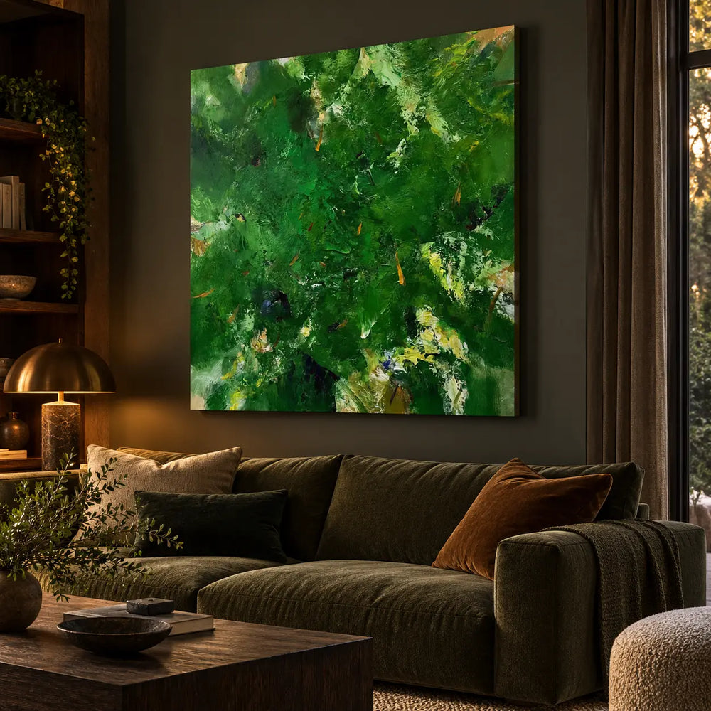 Verdant Immersion: Angled painting view above an olive sofa beside a bookshelf and brass lamp