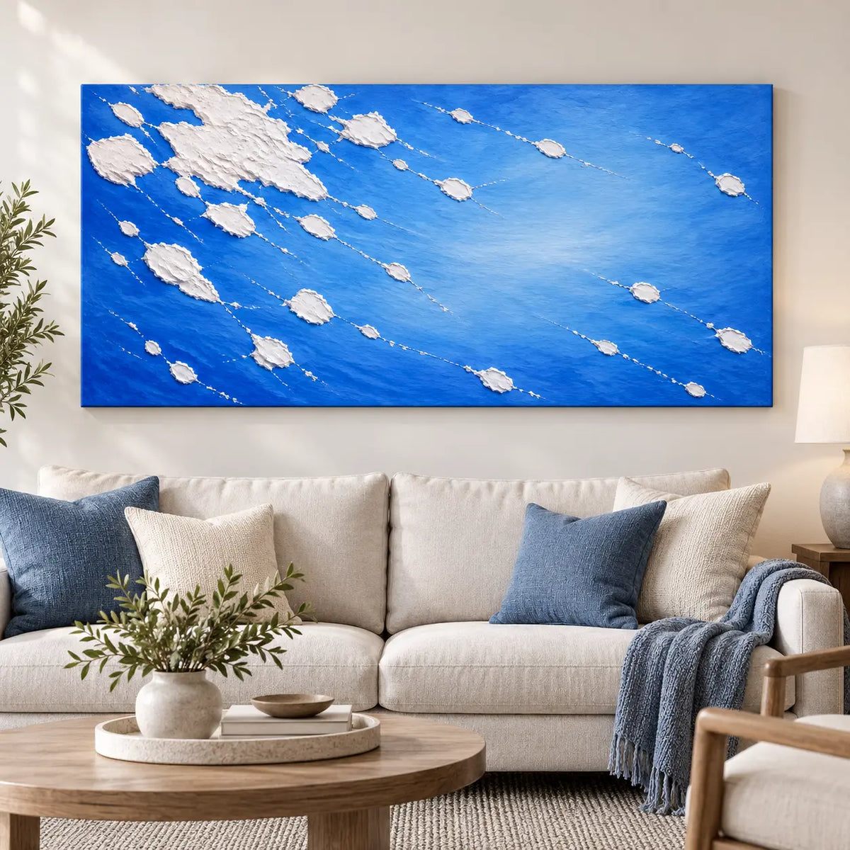 White Traces in Cobalt: above a cream sofa with blue cushions and a round wood table