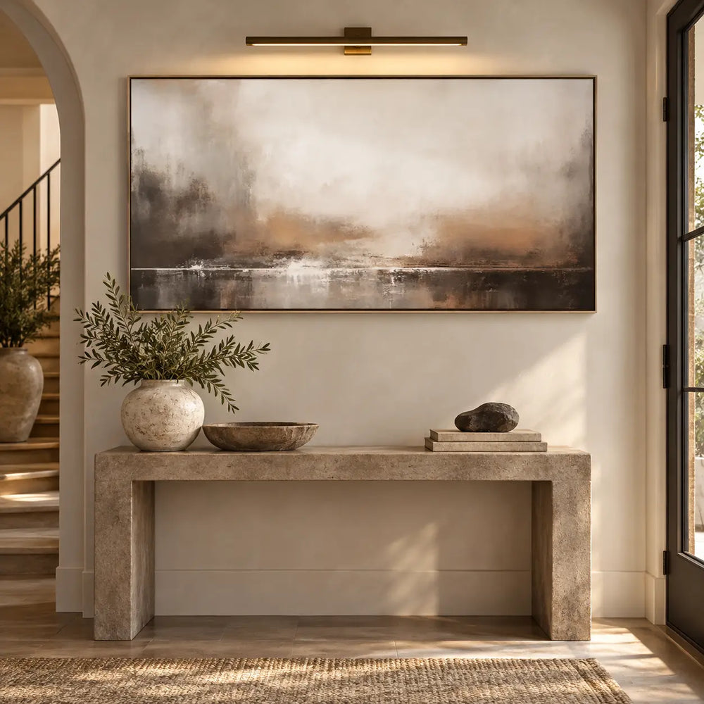 A Quiet Line of Light: above a stone console beneath a brass picture light