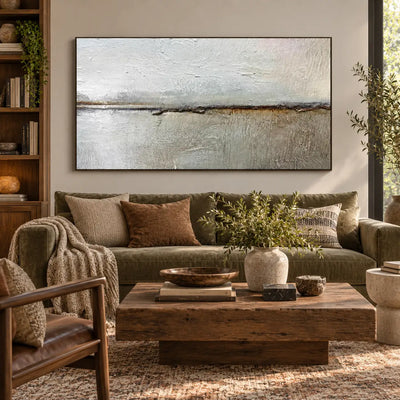 An Ochre Line in the Mist: above an olive sofa with a rustic wood table beside bookshelves