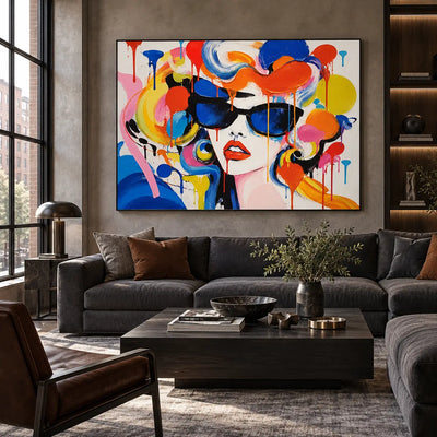 Blue Lenses and Tangerine Curls: artwork above a charcoal sofa beside a window and black coffee table
