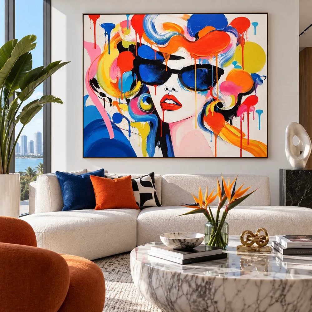 Blue Lenses and Tangerine Curls: artwork above a white sectional near a round marble table and orange flowers