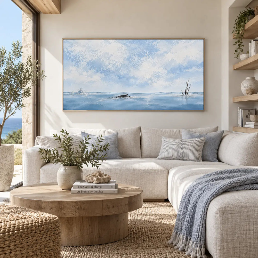 Branches in the Winter Expanse: above a cream sectional with a round wooden table and pale blue throw