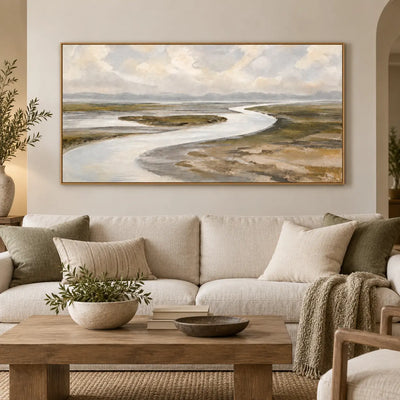 Estuary in Soft Weather above a long cream sofa with olive cushions and a wood coffee table