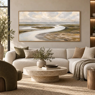 Estuary in Soft Weather above a wide ivory sofa with a green throw and pale round table