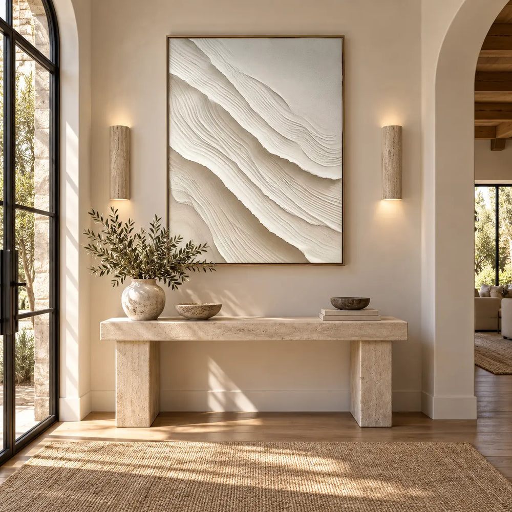 Folds Descending: textured canvas artwork above a stone entry console between two cylindrical wall lights.