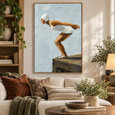 The Moment Before above a sofa with olive and rust cushions beside a trailing plant