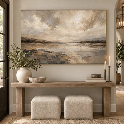 The Shore Beneath the Clouds above an entry console with a cushioned stool beside an arched hallway