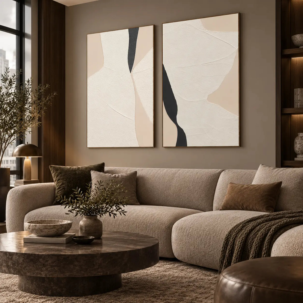 Two Openings in Cream: paired above a rounded cream sofa beside a city-view window