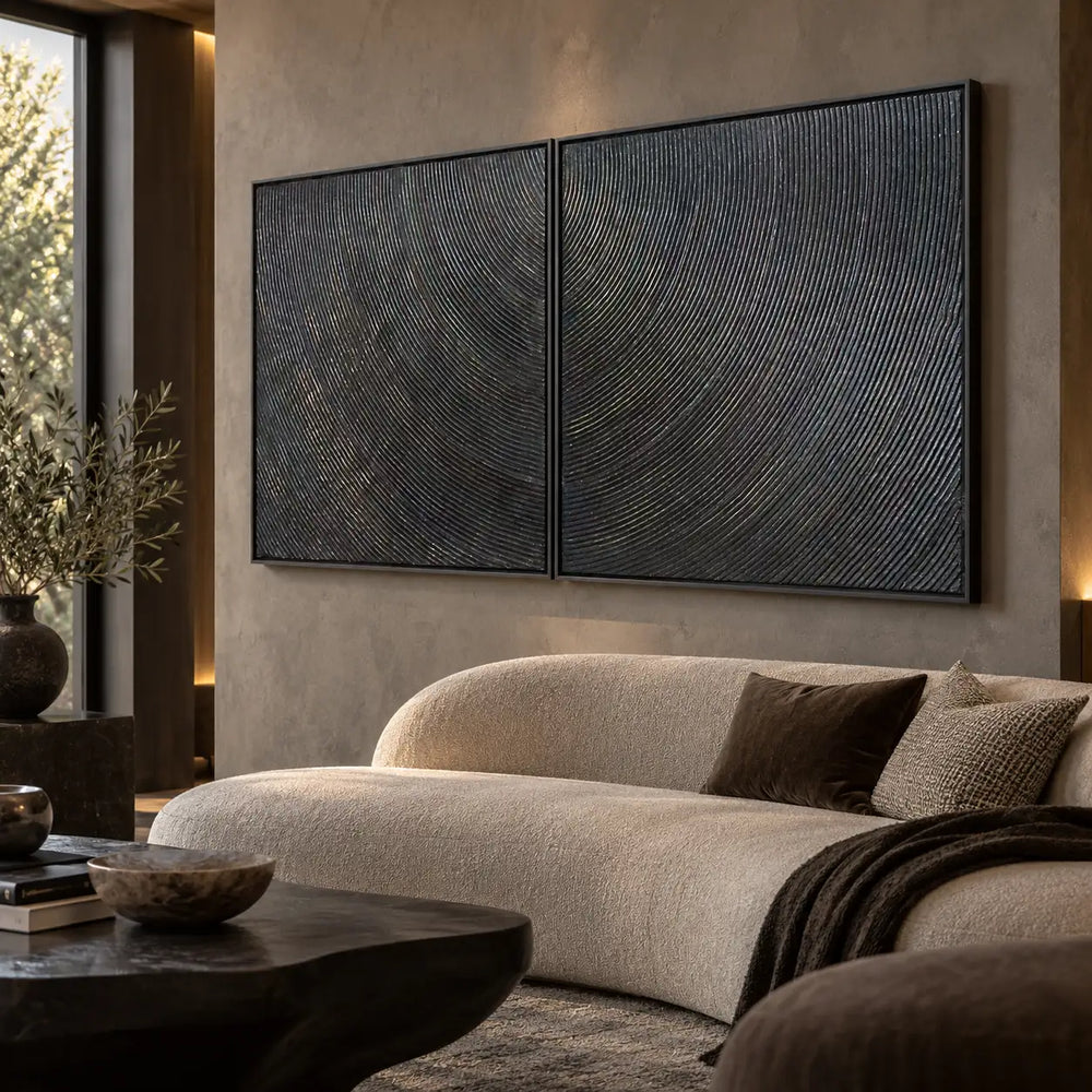 Two Rhythms in Charcoal: paired at an angle above a curved cream sofa beside a tall window