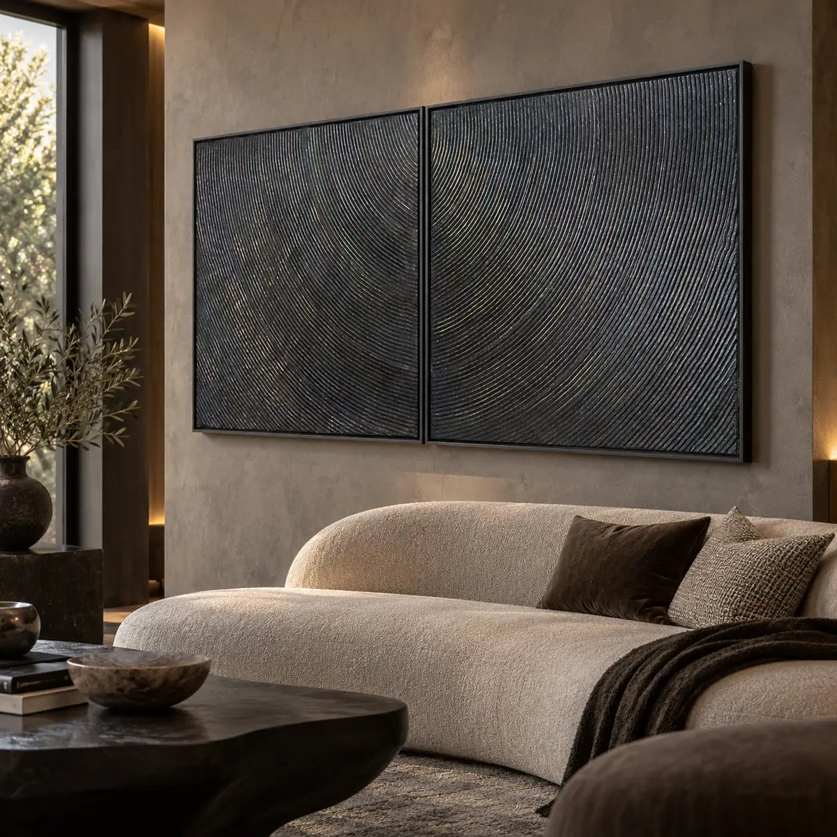 Two Rhythms in Charcoal: paired at an angle above a curved cream sofa beside a tall window