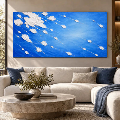White Traces in Cobalt: above a curved cream sectional and round pale stone table